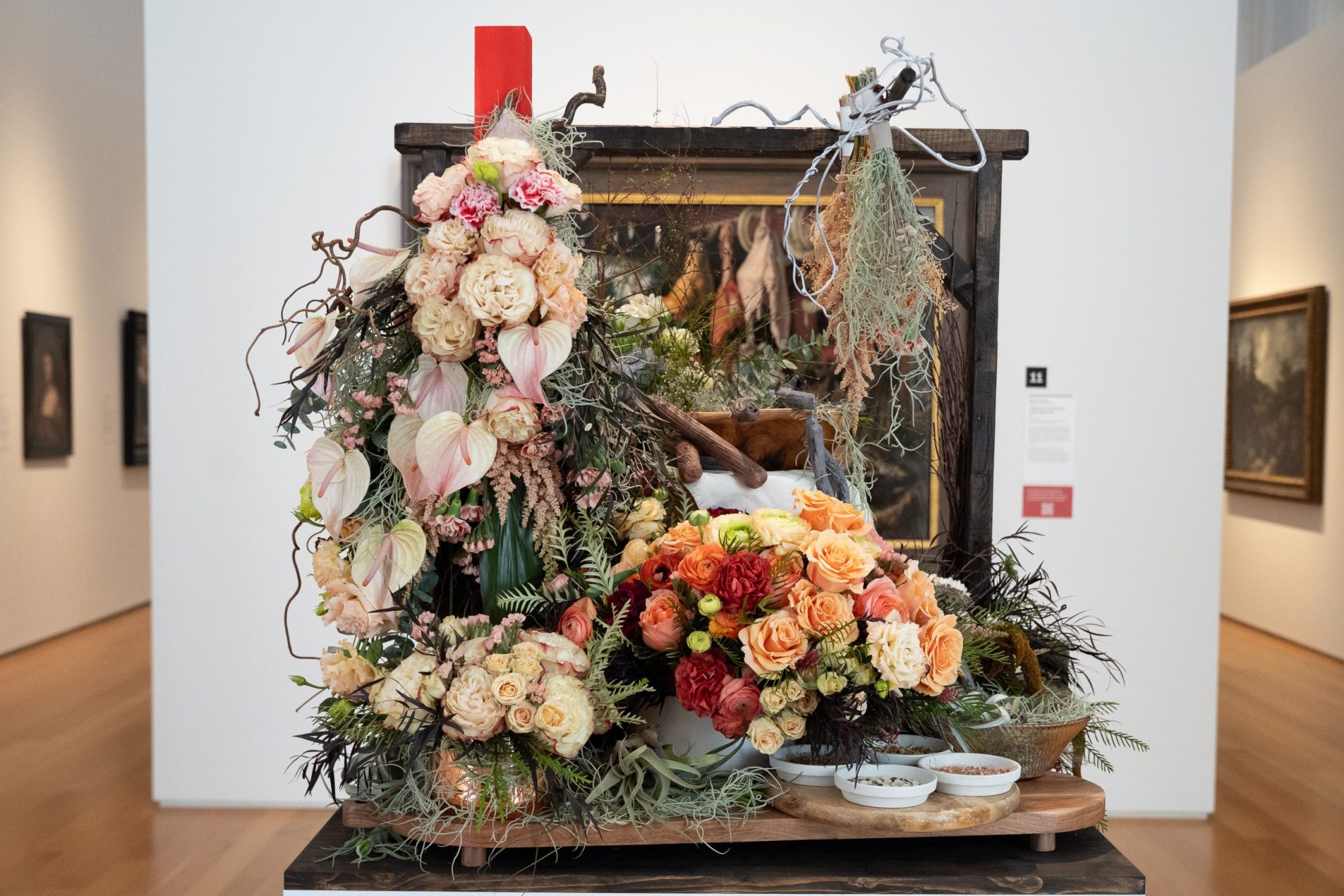 A floral piece by Tonia Gebhart of The Barefoot Artist, inspired by Pieter Aertsen’s “A Meat Stall with the Holy Family Giving Alms” is displayed during the 2025 Art in Bloom at the North Carolina Museum of Art on Tuesday, March 18, 2025, in Raleigh.